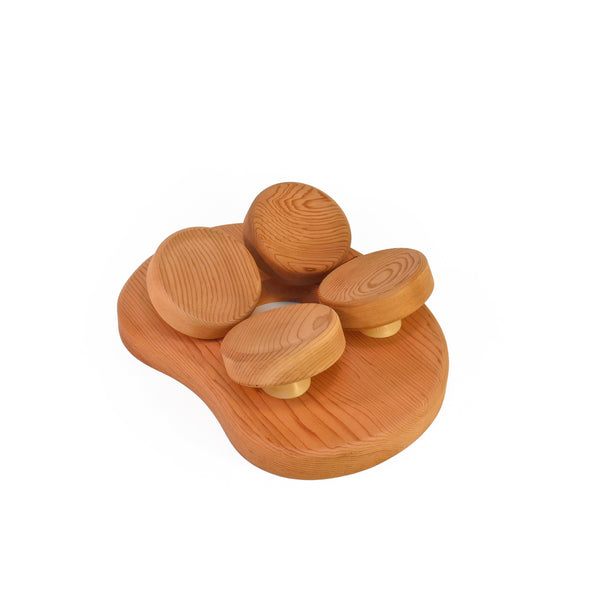 Cedar sauna pillow with four rotating wooden discs on white background.